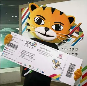  ?? — ROHAIZAT MD DARUS / The Star ?? Here you go: Kuala Lumpur SEA Games mascot Rimau holding a replica ticket during the launch of the ticket sales by Youth and Sports Minister Khairy Jamaluddin in Bukit Jalil yesterday.