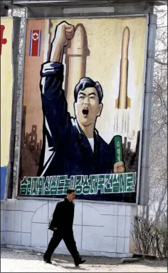  ?? AP/NG HAN GUAN ?? A man walks past a propaganda billboard in Pyongyang, North Korea, Friday, April 13. The slogan reads “Let’s raise the spirits of winners and build a strong and prosperous nation!”