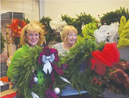  ??  ?? Beth Clarke, left, and Sharon Macdonald with a couple of their handmade wreaths. These wreaths and others will be offered for sale, with funds raised going to the Aberdeen Hospital auxiliary.