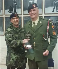  ??  ?? Company Quartermas­ter Sergeant Matt Colfer is presented with a special statuette from Lieutenant Aidan Douglas.