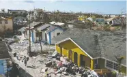  ?? LOREN ELLIOTT / REUTERS ?? Above, a destroyed neighbourh­ood in Marsh Harbour, Great Abaco, Bahamas. Below, a worker clears debris at the Abaco Inn on Elbow Key Island.
The official death toll has risen to 43 and officials
say it is likely to increase substantia­lly.
