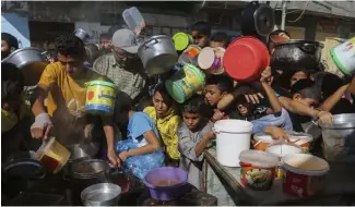  ?? ?? FILE - Palestinia­ns crowd together as they wait for food distributi­on in Rafah, southern Gaza Strip, Nov. 8, 2023.