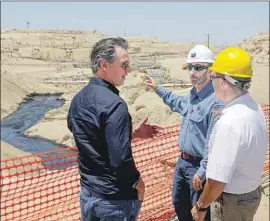  ?? Irfan Khan Los Angeles Times ?? GOV. GAVIN NEWSOM, left, tours the scene of a million-gallon spill in Kern County with Chevron’s Billy Lacobie, center, and state oil official Jason Marshall.