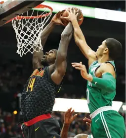  ?? (Reuters) ?? BOSTON CELTICS defender Jayson Tatum (right) blocks a dunk attempt by Atlanta Hawks center Dewayne Dedmon in the first quarter of the Celtics’ 110-99 road victory over the Hawks on Saturday night, a result that boosted Boston’s winning streak to 15...