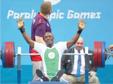  ??  ?? Nigeria's Yakubu Adesokan celebrates after setting a World record at the 2012 Paralympic Games in London with a lift of 177 kg.