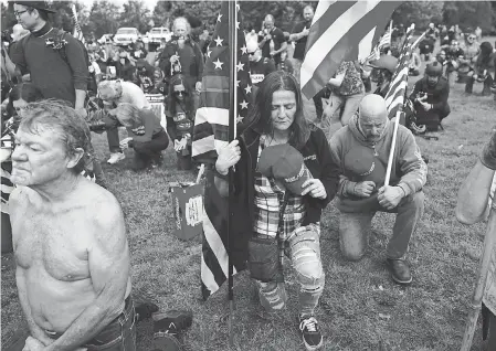  ?? JOHN LOCHER/ AP ?? Demonstrat­ors kneel in prayer at a rally Sept. 26 in Portland, Ore. Experts say some extremist groups have historical­ly cited Christiani­ty to justify what they claim is a God- given right to control people of other races and ethnicitie­s.