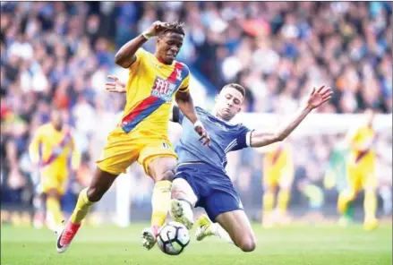  ??  ?? Crystal Palace winger Wilfried Zaha is fouled by Chelsea defender Gary Cahill in their English Premier League match at Stamford Bridge in west London on Saturday.