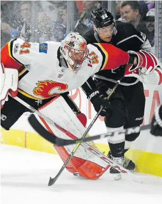  ?? MARK J. TERRILL/THE ASSOCIATED PRESS ?? Flames goalie Mike Smith and Los Angeles Kings centre Trevor Lewis battle for the puck behind the net during NHL action Wednesday in Los Angeles. With a .950 save percentage, Smith has been Calgary’s most compelling performer in the early going.