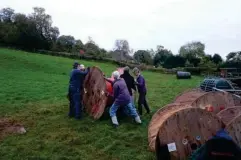  ?? (B4RN) ?? Keep rolling: locals move a reel of plastic across a field