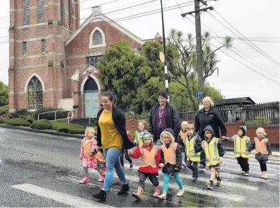  ?? PHOTO: STEPHEN JAQUIERY ?? Moving out . . . teachers (from left) Kim Ruthven and Roberta Carvalho, and head teacher Lyn Morton, cross the road with Andersons Bay Community Kindergart­en children outside the kindergart­en.