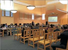  ?? NICHOLAS BUONANNO — NBUONANNO@TROYRECORD.COM ?? Cohoes residents and school faculty members listen as school business official Stacy Mackey discusses the proposed budget during a school board meeting Wednesday night.