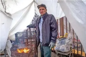  ?? FRANCINE ORR/LOS ANGELES TIMES/TNS ?? Carlos Parra Aguiar built a fire in a grocery cart to stay warm Feb. 24 in Los Angeles.