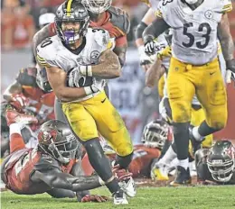  ?? Peter Diana/Post-Gazette ?? James Conner runs for a first down against Tampa Bay last Monday night at Raymond James Stadium. Conner’s two big runs at the end of the game helped seal the Steelers’ first win of the season. “It was nice to close it out,” Conner said.