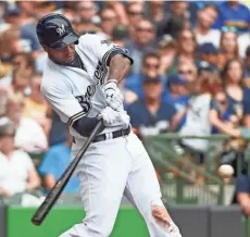  ?? BENNY SIEU / USA TODAY SPORTS ?? Brewers right fielder Domingo Santana clears the bases with a double in the fourth inning against the Marlins on Sunday at Miller Park.