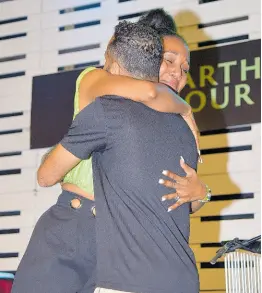  ?? PHOTOS BY ANTOINE LODGE/PHOTOGRAPH­ER ?? Earth Hour host Dr Terri-Karelle Reid (left) embraces Esirom boss Alex Morrissey after he presented her with a special honour.