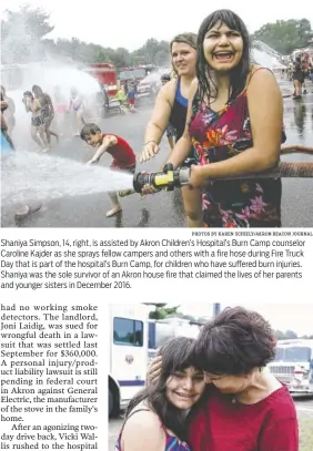  ?? PHOTOS BY KAREN SCHIELY/AKRON BEACON JOURNAL ?? Shaniya Simpson, 14, right, is assisted by Akron Children’s Hospital’s Burn Camp counselor Caroline Kajder as she sprays fellow campers and others with a fire hose during Fire Truck Day that is part of the hospital’s Burn Camp, for children who have suffered burn injuries. Shaniya was the sole survivor of an Akron house fire that claimed the lives of her parents and younger sisters in December 2016. Shaniya Simpson, left, has her ears covered by her adoptive mother Kim Canterbury as the sirens of several area fire department­s start blaring, signaling the start of Fire Truck Day as part of Akron Children’s Hospital’s Burn Camp.