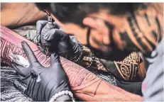  ?? ?? Die Entwürfe der Maori-Tattoos zeichnen die Künstler frei Hand auf die Haut auf. Ist der Kunde mit der Skizze zufrieden, folgt die Nadel.