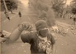  ?? Foto: reuters ?? Un hombre lanza una piedra a la policía militar durante una protesta en contra del gobierno hondureño en la capital del país, Tegucigalp­a