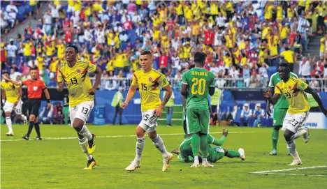  ?? /GETTY IMAGES ?? El árbitro señala el centro del campo mientras Yerry MIna y Mateus Uribe celebran el gol de Colombia.