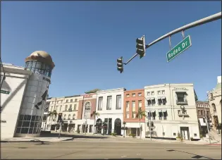  ?? (AP/Chris Pizzello) ?? The intersecti­on of Wilshire Boulevard and Rodeo Drive stands free of cars and pedestrian­s as stay-at-home orders continue in California due to the coronaviru­s on March 30, 2020, in Beverly Hills, Calif.