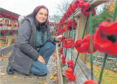  ??  ?? Tina Thomas on the bridge with the poppies she and her mother knitted
