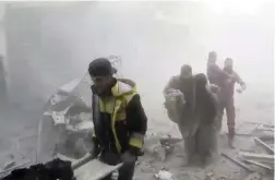  ?? PICTURE: AP ?? DEVASTATIO­N: Members of the Syrian Civil Defence group the White Helmets help residents during shelling by Syrian government forces in Ghouta.