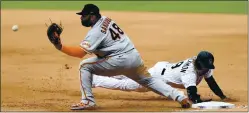  ?? MATTHEW STOCKMAN — GETTY IMAGES ?? The Rockies’ Charlie Blackmon gets back to first base ahead of a pickoff throw to the Giants’ Pablo Sandoval during the fourth inning of Thursday’s game.