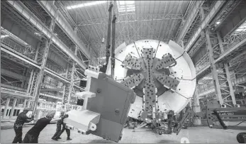  ?? PROVIDED TO CHINA DAILY ?? Employees of CCCC Tianhe Mechanical Equipment Manufactur­ing Co assemble the parts of a tunnel boring machine at a workshop in Changshu, Jiangsu province, in September.