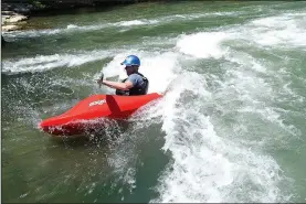  ?? NWA Democrat-Gazette/FLIP PUTTHOFF ?? Alan Kearney of Bella Vista rides the waves in June at the Siloam Springs Kayak Park on the Illinois River. The free park offers white water for paddlers to test their skills, plus calm water for swimming.