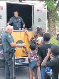  ??  ?? Coatesvill­e Police Chief Jack Laufer, left, and Coatesvill­e Officer Tyler Famous, center, hand out Rita’s water ice in Coatesvill­e City during National Night Out on Tuesday.