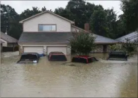  ?? MICHAEL CIAGLO — HOUSTON CHRONICLE (VIA AP) ?? A home and vehicles in Houston are partly submerged on Tuesday.