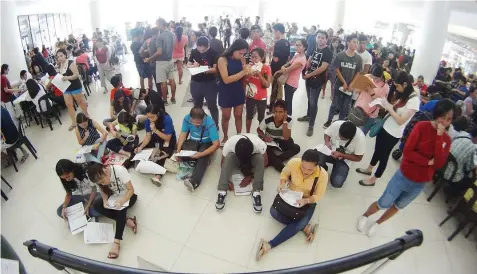  ?? PAUL JUN E. ROSAROSO ?? Voters flock to a satellite center of the Commission on Elections at the Ayala Center Cebu to beat the last day of the registrati­on yesterday.