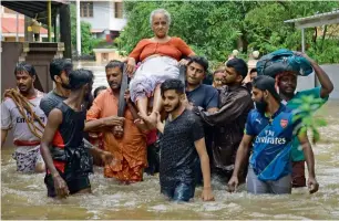  ?? PTI ?? An elderly woman is rescued following a flash flood, triggered by heavy rains, in Palakka. —