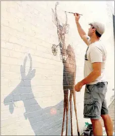  ?? Janelle Jessen/Siloam Sunday ?? Artist Jason Jones painted a mural of a deer on the side of Ability Tree on Thursday morning. The mural is the second in a series of three fun and playful animals in downtown Siloam Springs.