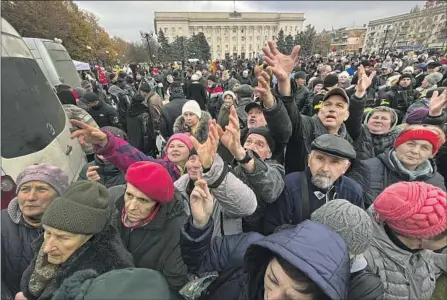  ?? Photograph­s by Carolyn Cole Los Angeles Times ?? UKRAINIANS gather in Kherson’s central square to receive food aid Friday, a week after Russia acknowledg­ed it had left the city.