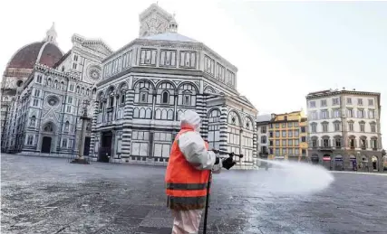  ?? — AFP ?? An employee of the municipal company disinfects Piazza del Duomo in Florence, Italy, on Saturday, as part of the measures taken by Italian government to fight against the spread of the novel coronaviru­s.