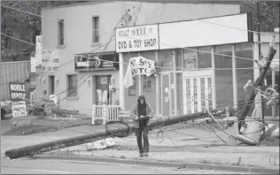  ?? NATHAN DENETTE/ THE CANADIAN PRESS ?? A Toronto Hydro worker overlooks the damage in city on Tuesday. Power lines were knocked down in various parts of Canada’s largest city, leaving some neighbourh­oods without electricit­y.