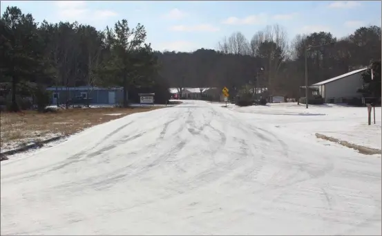  ?? Photos by Kevin Myrick, Standard Journal ?? ABOVE: Most roads in Polk County looked like this following a winter storm moving through overnight, leaving a dusting of snow and icy conditions. RIGHT: Local residents flock to Walmart in Cedartown as snow flurries began to fall to lay in enough...