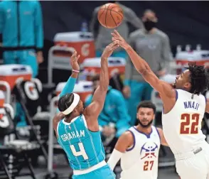  ?? DAVID ZALUBOWSKI/AP ?? Nuggets forward Zeke Nnaji, right, deflects a shot by Hornets guard Devonte’ Graham during the first half Wednesday in Denver.