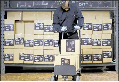  ?? Bloomberg News/JIM YOUNG ?? A worker pushes a hand truck at the BSD Industries facility in Chicago in December. The rise in wholesale prices in January is seen underscori­ng signs of stronger inflation.