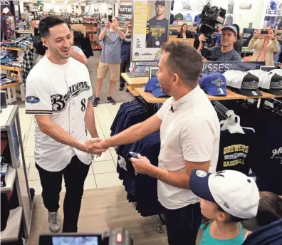  ?? RICK WOOD / MILWAUKEE JOURNAL SENTINEL ?? Brewers outfielder Ryan Braun greets Kevin Oelke and his family Wednesday at Kohl’s in Menomonee Falls. The family received a gift card to purchase Brewers fan gear for the National League Division Series.