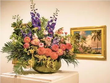  ?? PATRICK CONNOLLY/ORLANDO SENTINEL ?? An arrangemen­t by Eileen Tongson of FarmGal Flowers was inspired by a painting by Florida landscape painter Albert Backus for Art in Bloom at Orlando Museum of Art.