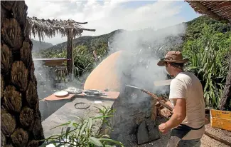  ??  ?? Toto’s Cafe and Pizzeria’s popular wood-fired pizzas are cooked in an outdoor clay oven. Crian Cahusac and Carole Fournier opened the pizzeria on a secluded piece of land five years ago.