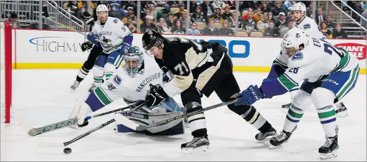  ?? — GETTY IMAGES FILES ?? Pittsburgh’s Evgeni Malkin battles Canucks goalie Ryan Miller and forward Emerson Etem, right, in a 5-4 Penguins victory Saturday in Pittsburgh.