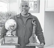  ?? Courtesy of Eric Gordon Sr. ?? Eric Gordon Sr. is a proud father, cradling his son’s NBA Sixth Man of the Year trophy under his right arm and the 3-point contest trophy in his left.