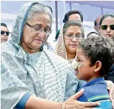  ??  ?? Bangladesh­i Prime Minister Sheikh Hasina meets a Rohingya Muslim child at Kutupalong refugee camp in Bangladesh on Tuesday. — AP