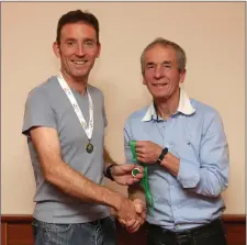  ??  ?? Gary Condon receives his over-45 Leinster gold medal from Terry Kavanagh.