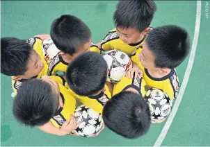  ??  ?? Students attend a football training session at their school in Minhang District in Shanghai.