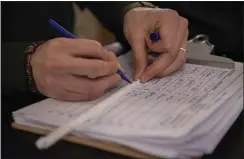  ??  ?? Zach Rybarczyk, who works for the D.C. Department of Energy and Environmen­t, writes the name of a Union Station restaurant on the sleeve of a plastic straw.