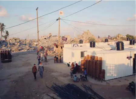  ??  ?? Palestinia­ns gather near mobile homes provided by a UAE associatio­n for families. Authoritie­s in Gaza Strip estimate that 17,000 homes were destroyed during the latest conflict with Israel